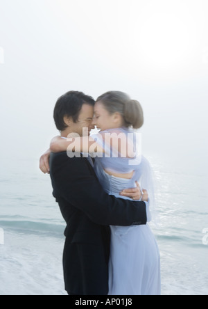 Sposa e lo sposo abbracciando sulla spiaggia Foto Stock