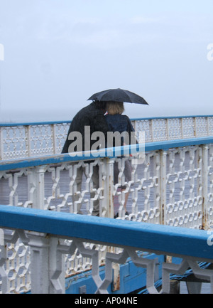 Giovane sotto ombrellone in Llandudno Pier, il Galles del nord Foto Stock