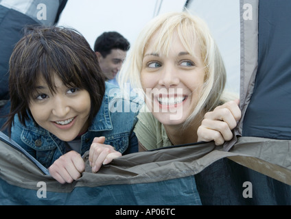 Due giovani amici di sesso femminile guardando fuori della tenda Foto Stock