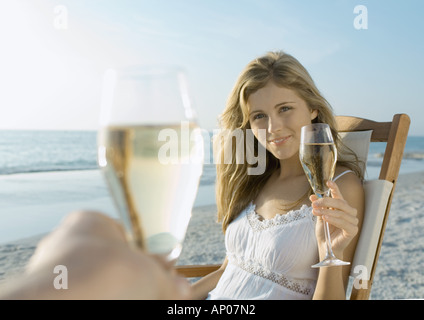 Paio di bere champagne sulla spiaggia Foto Stock