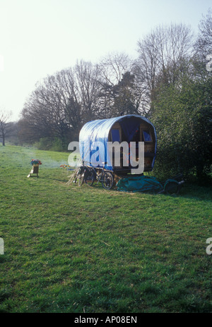 Walton, Somerset, Regno Unito. I viaggiatori singoli roulotte su terra comune con le biciclette campfire vendita di fiori di carta Foto Stock