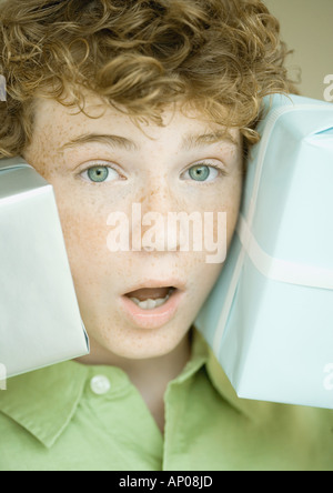 Ragazzo tenendo premuto fino presenta su due lati della faccia Foto Stock