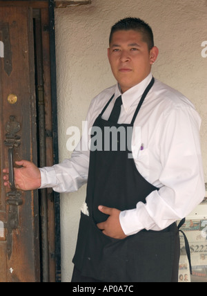 Operaio ispanico della ristorazione in uniforme in un ristorante degli Stati Uniti sud-occidentali, che rappresenta la manodopera dell'industria dei servizi e la presenza della forza lavoro latina. Foto Stock