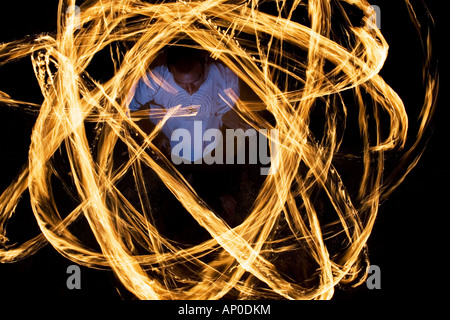 Fire ballerini patternMan Fire dancing con bastoni di fuoco di notte. India. Configurazione astratta. Esposizione lunga Foto Stock