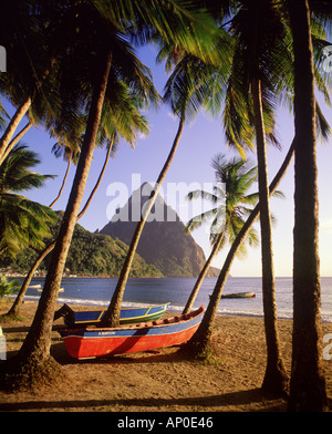 La torre Pitons sopra la spiaggia di Soufriere sull'isola caraibica di Santa Lucia come barche da pesca si trova sulla spiaggia Foto Stock