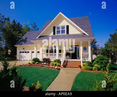 Piccola storia di due casa gialla con persiane nero un ampio portico e rivestire con mattoni i passaggi Foto Stock