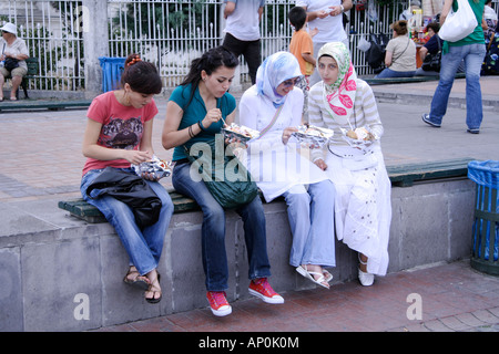 Moderno e tradizionale turco giovani ragazze avente prendere via il cibo in Istanbul TURCHIA Foto Stock