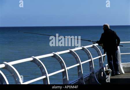 Il pescatore pesca al largo Cromer Pier North Norfolk, Regno Unito. Foto Stock