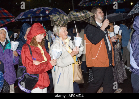 Pellegrini in processione a lume di candela sulla serata piovosa Lourdes Francia Foto Stock