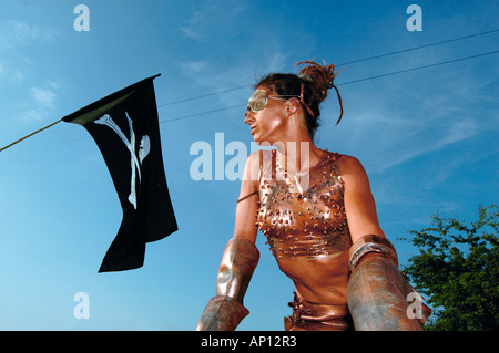 Un membro del gruppo anarchico alto esecuzione in gomma in bronzo il colore per body painting in occasione dell'annuale festival di Glastonbury nel Somerset Foto Stock