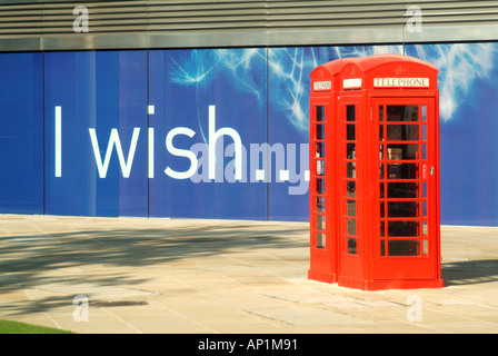 Londra palizzata pannelli attorno ad una quasi completa blocco ufficio segno scritto con desidero slogan telefono rosso pedonale scatole Foto Stock