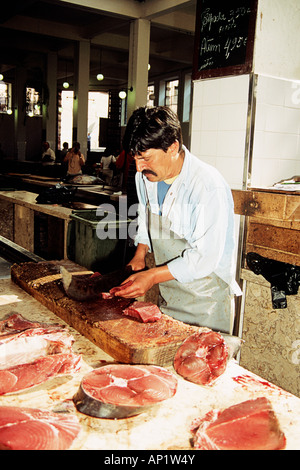 Pescivendolo preparare i filetti di pesce nel mercato del pesce, Funchal, Madeira Foto Stock