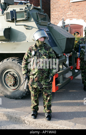 Esercito britannico Soldato Antisommossa in ingranaggio con sassone di personale armato veicolo portante su crumlin road presso negozi di ardoyne belfast Foto Stock