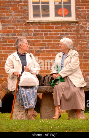 Due anziane signore chiacchierando OUTIDE il negozio del villaggio e ufficio postale a BRIANTSPUDDLE NEL DORSET REGNO UNITO Foto Stock