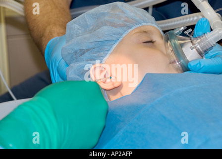 Ragazzo giovane sottoposti a chirurgia dell'orecchio in ospedale in sala operatoria Foto Stock