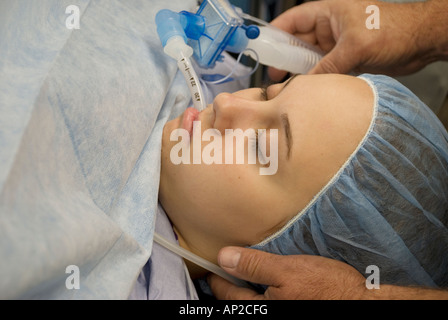 Femmina paziente adolescente sotto anestesia durante la procedura chirurgica Foto Stock