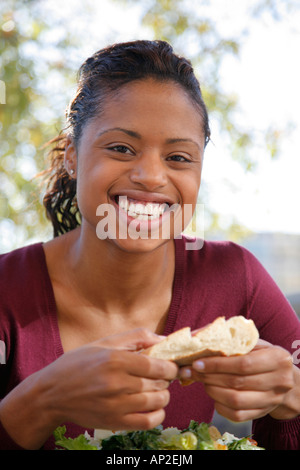 Giovane donna 20-25 anni di mangiare insalata e pane nel ristorante all'aperto, signor-10-31-07 Foto Stock