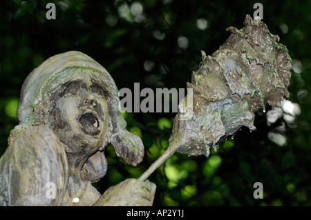 Una grottesca statua di pietra in una country house garden in Staffordshire Foto Stock