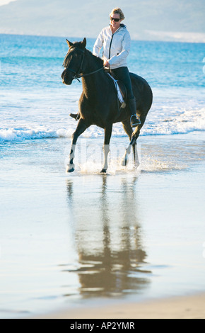 Giovane donna cavallo in riva alla spiaggia Foto Stock