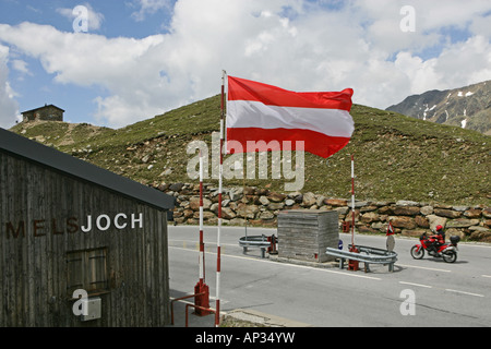 Bandiera austriaca, tour in moto in giugno su valichi alpini, summit pass a Passo Rombo tra Austria e Italia Foto Stock