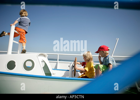 Bambini che giocano in una barca su un parco giochi, il lago di Starnberg, Baviera, Germania Foto Stock