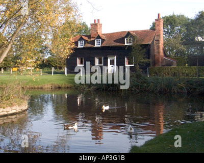 Blackmore Laghetto vicino a Chelmsford Essex con bianco e nero cottage in background Foto Stock
