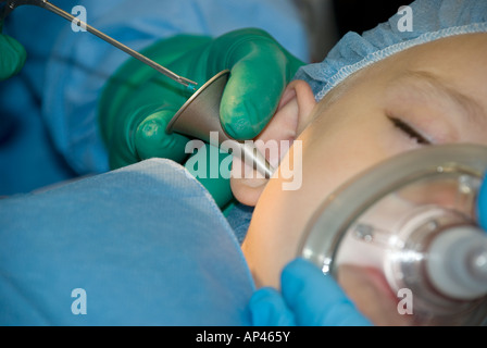 Ragazzo giovane sottoposti a chirurgia dell'orecchio in ospedale in sala operatoria Foto Stock