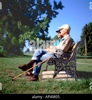 Due uomini anziani seduti su una panchina nel parco ricordando a Niagara Park a Fort Erie, Ontario, Canada KATHY DEWITT Foto Stock