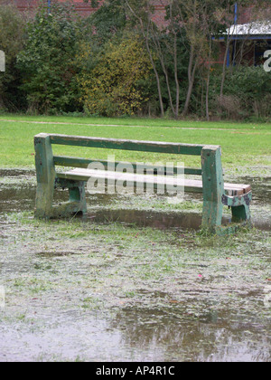 Una panchina nel parco parzialmente sommerse da inondazioni nel Regno Unito Foto Stock