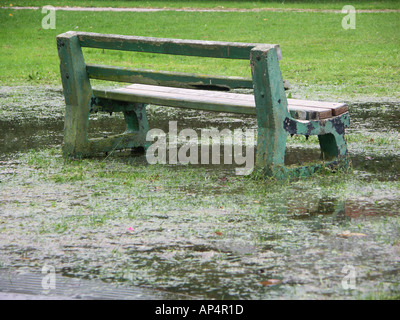 Una panchina nel parco parzialmente sommerse da inondazioni nel Regno Unito Foto Stock