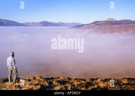 Guardando verso il basso su una nebbia riempito Loch Lomond dalla collina conica vicino a Balmaha Ben Lomond è in sfondo a destra Foto Stock