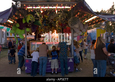 Un premio e dono dello stand è un attrazione per molti presso la Utah State Fair in SLC, Utah, Stati Uniti d'America. Un tramonto che brilla attraverso i giocattoli appesi Foto Stock