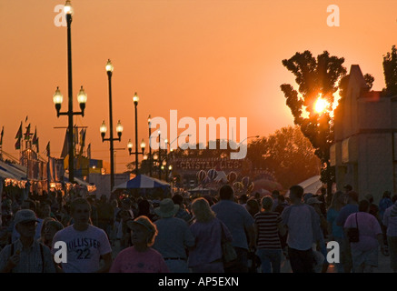 Patrocini & visitatori della Utah State Fair walking midway come crepuscolo approcci. Il sole è quasi set & tutti è in ombra. Foto Stock