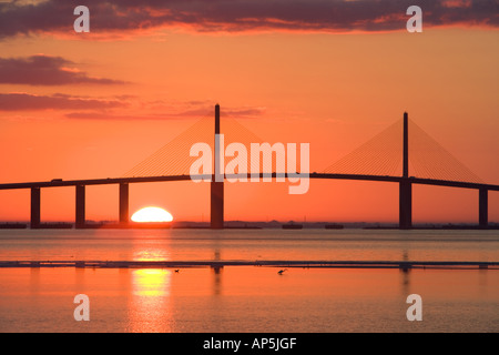 Il sole sorge dietro il Sunshine Skyway Bridge come visto da Fort De Soto Park a Pinellas County, Florida. Foto Stock
