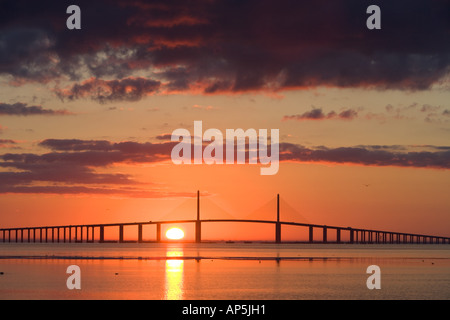 Il sole sorge dietro il Sunshine Skyway Bridge come visto da Fort De Soto Park a Pinellas County, Florida. Foto Stock