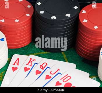 Mano di Poker che mostra un Royal Flush circondato da chip di gioco Foto Stock