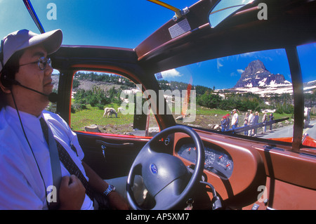 Jammer rosso tira bus fino a Logan pass e delle capre di montagna nel Parco Nazionale di Glacier Montana Foto Stock