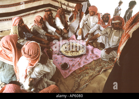 Arabia Saudita, Empty Quarter. Al Murrah beduino attendere il segnale di start per scavare nella festa del cammello carne e riso Foto Stock