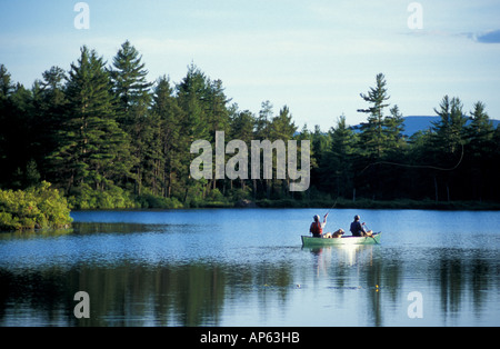 Libertà, NH Pesca a Mosca da una canoa in trota laghetto. Parte del futuro paese foresta. (MR) Foto Stock