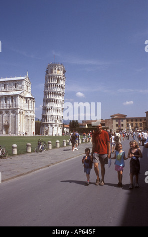 Padre e figli che camminano in vacanza a Pisa con la torre pendente di Pisa in background Foto Stock