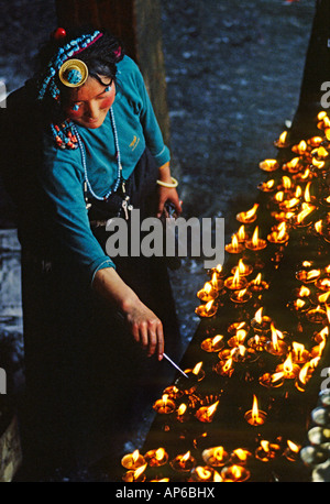 Una donna tibetana posizioni di lampade a burro al JOKHANG TIBET S più sacro tempio costruito da Re SONGTSEN GAMPO LHASA TIBET Foto Stock