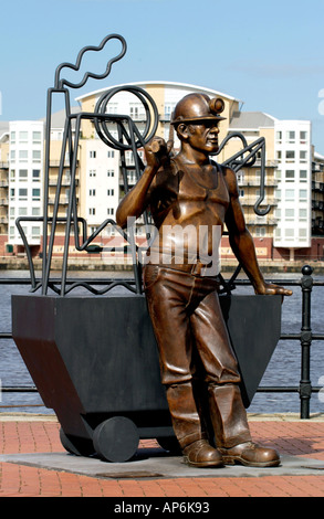 La scultura di minatori gallese dall artista John Clinch sul Quayside in Cardiff Bay di fronte all'appartamento blocco South Wales UK Foto Stock