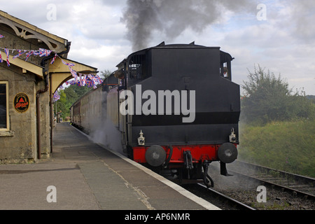 Motore a vapore da est Summerset Railway lascia la stazione sotto una nuvola di polvere di carbone e vapore Foto Stock