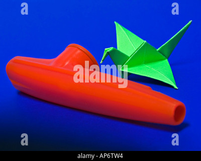 Kazoo e un cigno di carta su sfondo blu Foto Stock