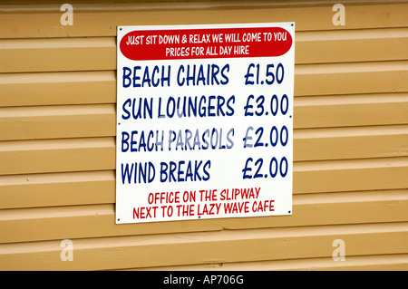 Un segno pubblicità presso la spiaggia per sedie a sdraio e lettini a sdraio sul lato di una capanna sulla spiaggia vacanze al mare Foto Stock