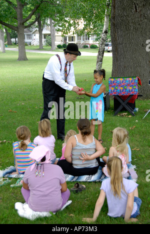 Mago esegue trucchi di magia per i bambini Foto Stock