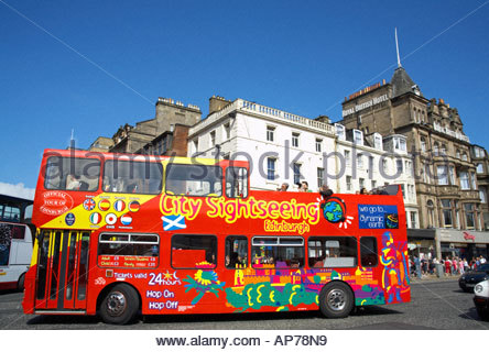 Un rosso autobus turistico viaggia lungo Princes Street, Edimburgo in Scozia Foto Stock