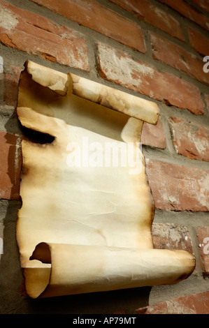 Vecchia pergamena in bianco con bordi masterizzato su un rosso muro di mattoni Foto Stock