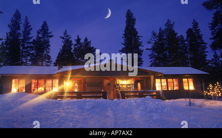 Cabina di montagna sotto la luna crescente e la neve in inverno Foto Stock