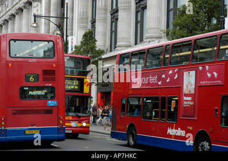 Autobus rossi di Londra passando dal grande magazzino Selfridges di Oxford Street London REGNO UNITO Foto Stock